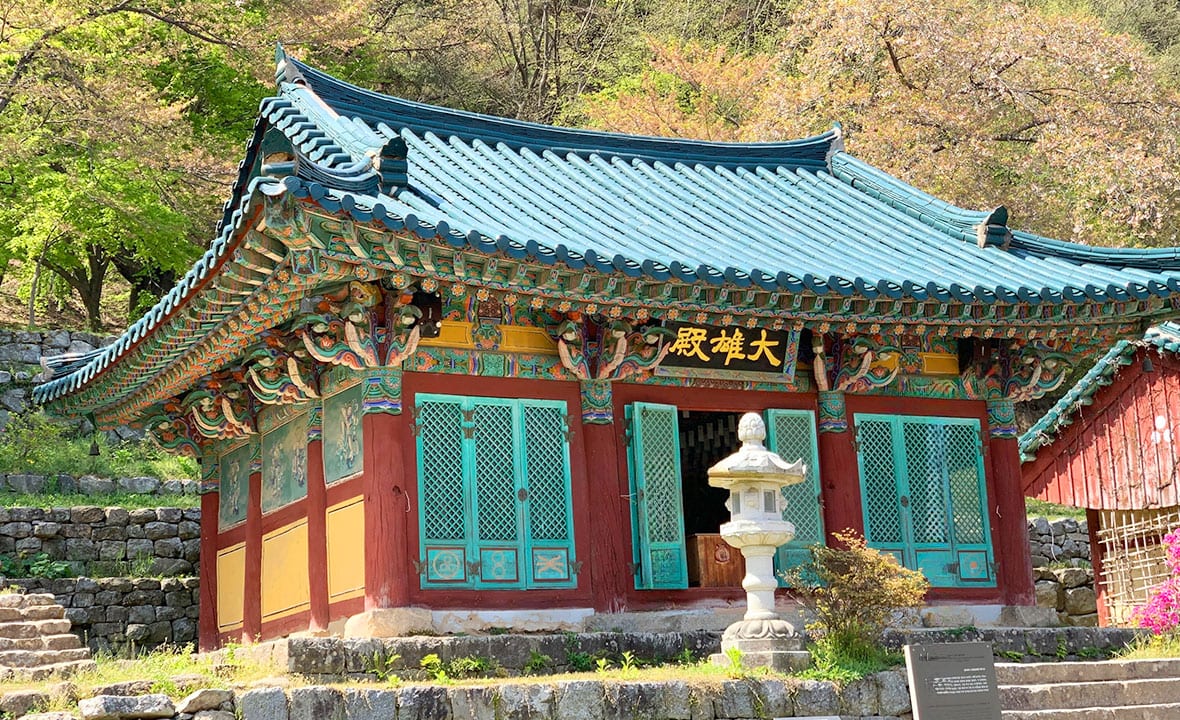석등 뒤로 푸른 기와를 얹은 대원사 대웅전