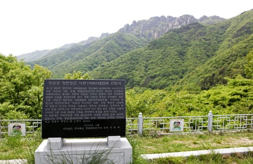 황진 장군 이치대첩비 건립기를 새긴 검은 비석, 뒤로 숲 너머 대둔산 바위 능선